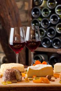 zwei Gläser Wein und Käse auf einer Tafel in der Unterkunft Logis Arts et Terroirs in Gevrey-Chambertin