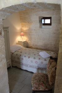 una camera da letto con un letto e una sedia in una stanza di Trullo Monte Grappa ad Alberobello