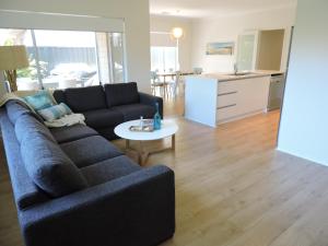 a living room with a couch and a table at Contemporary Cove - Quindalup in Quindalup