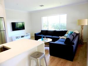 a living room with a couch and a table at Contemporary Cove - Quindalup in Quindalup