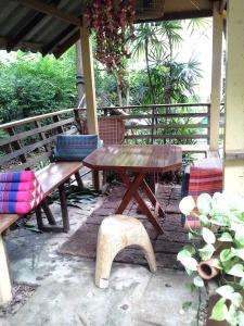 a wooden picnic table and bench on a patio at At Home Sukhothai in Sukhothai