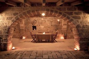 a dining room with a table in a stone wall at Masseria Nucci - Autentica Dimora Storica in Nardò