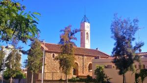 a church with a clock tower on top of it at Mia Beach-City apartment in Montgat