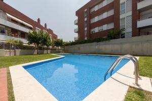 a swimming pool in front of a building at Mia Beach-City apartment in Montgat
