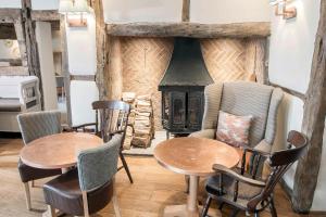 a living room with two tables and a stove at Kings Court Hotel in Alcester