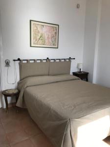 a bedroom with a large bed with a tan bedspread at Residenza Le Serre in Acciaroli