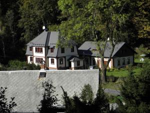 ein großes Haus hinter einem weißen Zaun in der Unterkunft Apartmany Chribska in Chřibská