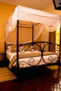 a black bed with a canopy in a room at Casa Mia Lodge & Restaurant in Blantyre
