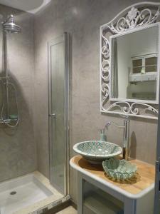 une salle de bain avec un lavabo, une douche et un miroir dans l'établissement Mas Bonement, à Arles