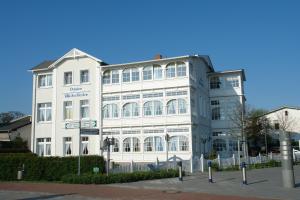 a white building with a sign in front of it at Pension Villa Seefrieden in Binz