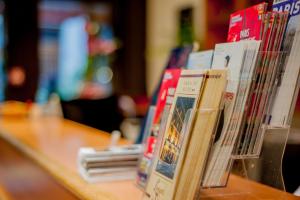 una fila de libros sentados en una mesa en Hotel Leonard De Vinci, en París