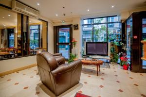 uma sala de estar com uma cadeira de couro e uma televisão em Hotel Leonard De Vinci em Paris