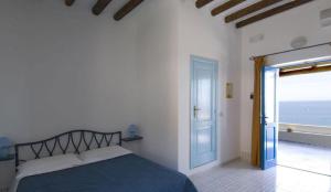 a bedroom with a bed and a door to the ocean at Hotel Girasole in Panarea
