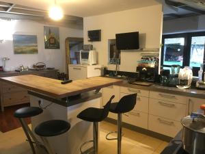 a kitchen with two bar stools and a counter at Chambre d’hotes Le Grand Fourneau in Lassay-sur-Croisne