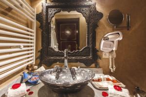 a bathroom with a sink and a mirror at Riad Fes Maya Suite & Spa in Fez