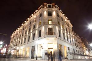 Un grand bâtiment blanc avec des personnes debout devant lui dans l'établissement Europa Royale Bucharest, à Bucarest