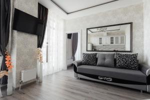 - un salon avec un canapé et un miroir dans l'établissement City Center Apartment, à Odessa