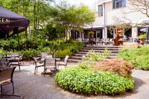 a patio with chairs and tables and stairs with a building at Fletcher Hotel Restaurant Epe-Zwolle in Epe