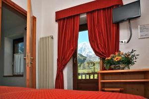 a bedroom with a window with a view of a mountain at Albergo Le Marmotte in Pré-Saint-Didier