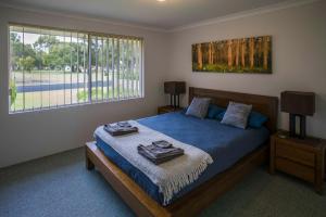 a bedroom with a bed and a large window at Indoyo Retreat in Busselton