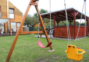 two swings in a yard with a house at Private holiday house Vivendi in Liptovský Mikuláš