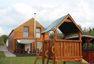 a tiny house with a swing and a playground at Private holiday house Vivendi in Liptovský Mikuláš