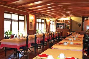 普雷聖迪迪埃的住宿－土撥鼠旅館，用餐室设有桌椅和窗户。
