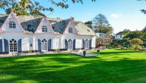 een groot huis met een grote tuin met groen gras bij The Woodlands Hotel in Sidmouth
