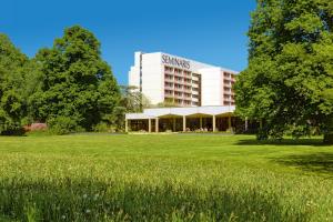 un edificio con un campo delante de él en Seminaris Hotel Lüneburg, en Lüneburg