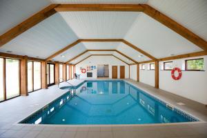 a pool in a house with a large ceiling at Green Acres Cottages in Par
