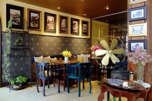 een eetkamer met blauwe stoelen en een tafel bij Old Capital Bike Inn - SHA Certified in Bangkok