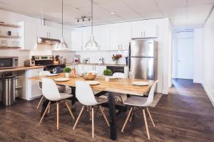 a kitchen with a wooden table and white cabinets at MtlVacationRentals - The Entertainer in Montreal