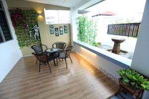 a room with chairs and a table and a balcony at Come Inn Homestay 1380 in Miri