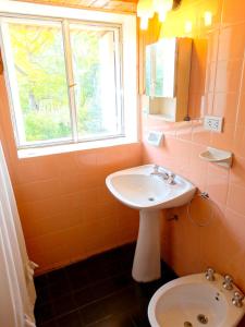 a bathroom with a sink and a toilet and a window at La Casa del Tata in Potrerillos