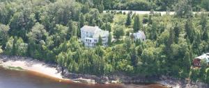 an aerial view of a house on an island in the water at Auberge de la Rivière Saguenay in La Baie