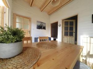 drewniany stół z doniczką na górze w obiekcie By The Sea Lodges w mieście Wrzosowo