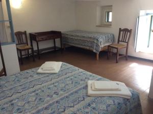 a room with two beds and a table and two chairs at Villino with Garden in Tropea