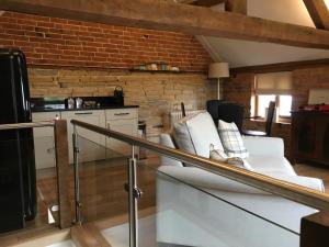 a living room with a white couch and a brick wall at Leila in Stratford-upon-Avon