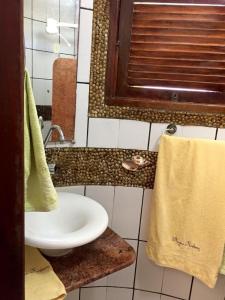 a bathroom with a white sink and a towel at Pousada Acgua Residenz in Cabo de Santo Agostinho