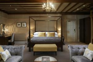 - une chambre avec un lit, deux chaises et un lustre dans l'établissement The Manor Elstree, à Elstree