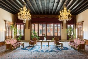 a living room with chandeliers and a table and chairs at Hotel Liassidi Palace in Venice