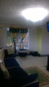 sala de estar con sofá y 2 ventanas en Cabaña Los Hayuelos, en Paipa