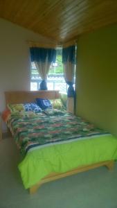 1 cama con marco de madera en un dormitorio en Cabaña Los Hayuelos, en Paipa