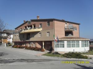 ein großes Gebäude an der Straßenseite in der Unterkunft residence la collinetta in Cagli