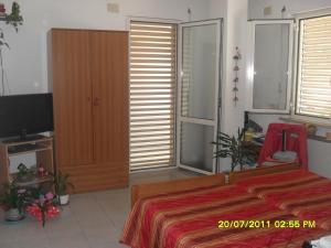 Schlafzimmer mit einem Bett und einem TV in der Unterkunft residence la collinetta in Cagli