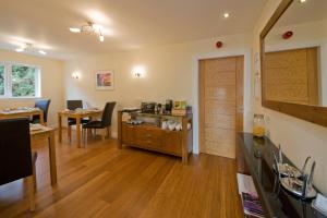 a living room with a table and chairs and a door at Aspen Lodge in Oban