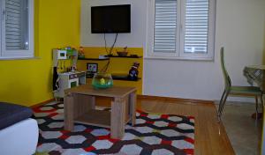 ein Wohnzimmer mit Tisch und Fernseher in der Unterkunft Apartmani Mihaela Dobropoljana 52 in Dobropoljana
