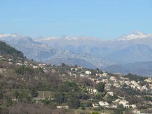 una ciudad en una colina con montañas en el fondo en Hotel mon Soleil, en La Gaude