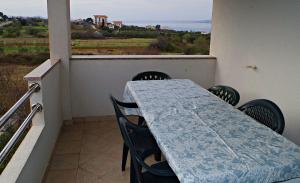 ein Tisch und Stühle auf einem Balkon mit Blick auf das Meer in der Unterkunft Apartmani Mihaela Dobropoljana 52 in Dobropoljana