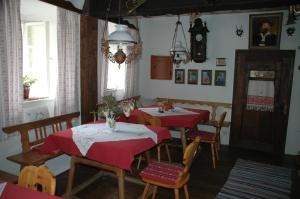 una sala da pranzo con tavoli e sedie rossi e un orologio di Romantikhaus Hufschmiede a Engelhartszell